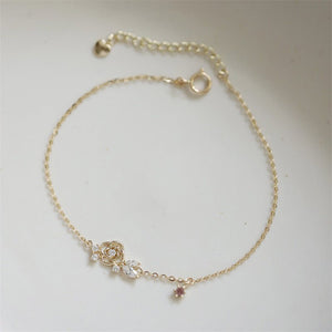 Gold bracelet with floral design on a light gray background