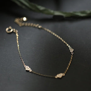 Delicate gold bracelet on a dark surface
