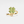 Gold ring with green clover-shaped design on a light beige background