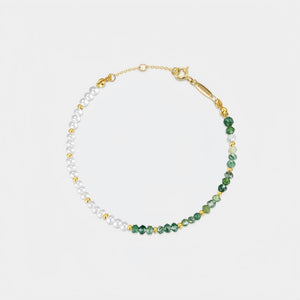Necklace with green and white beads on a light gray background