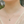 Necklace with a green pendant worn by a person