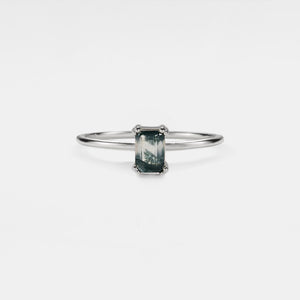 Silver ring with a green gemstone on a white background
