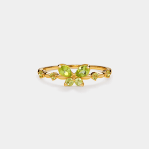 Gold ring with green gemstones on a white background