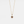 Gold necklace with a pendant featuring a red gemstone on a light gray background