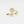 Gold ring with diamond accents on a light gray background