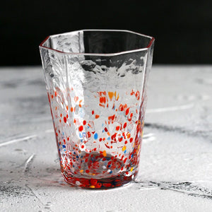 Clear glass with colorful speckles on a textured surface