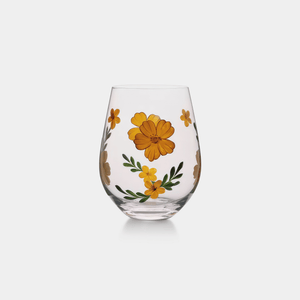 Clear glass stemless wine glass with yellow floral designs on a white background