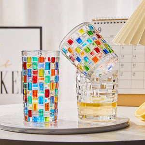 Colorful glass tumblers on a table with a blurred background