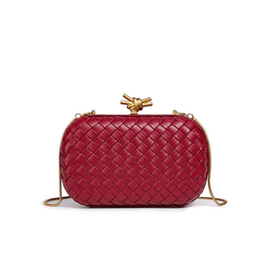 Red woven handbag with gold accents on a white background
