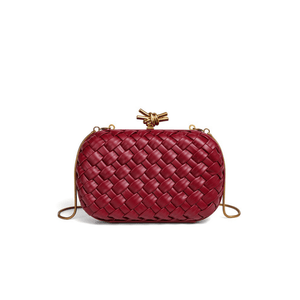 Red woven handbag with a gold clasp on a white background