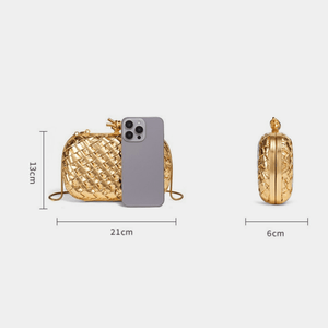 Gold woven handbag with dimensions and a phone for scale on a white background