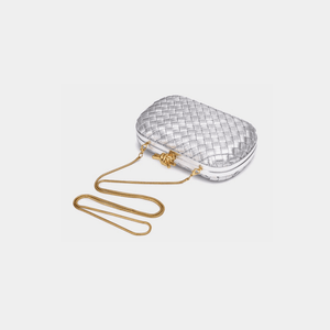 Silver woven handbag with a gold chain on a light gray background