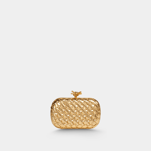 Gold woven clutch bag on a light gray background