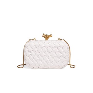White woven handbag with gold accents on a white background