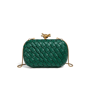 Green woven handbag with gold accents on a white background