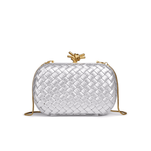 Silver woven handbag with a gold handle on a white background