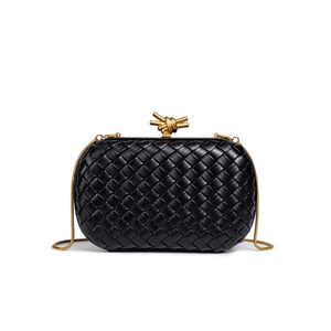 Black woven handbag with gold accents on a white background