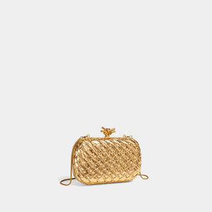 Gold woven handbag on a light beige background