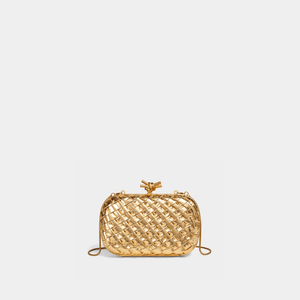 Gold woven handbag on a light gray background