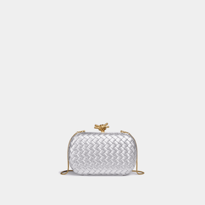 Silver woven handbag with a gold clasp on a light gray background