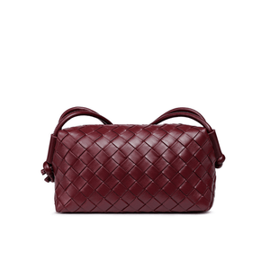 Maroon woven handbag on a white background