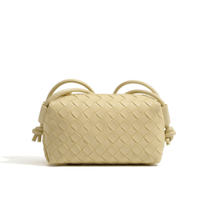 Beige woven handbag on a white background