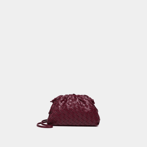 Maroon woven handbag on a light gray background