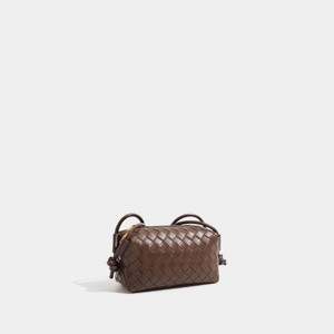 Brown woven handbag on a light gray background