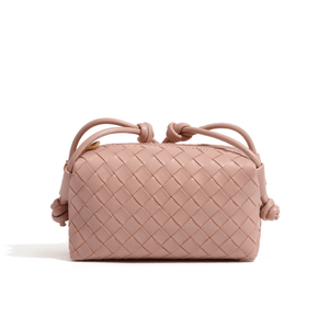 Blush pink woven handbag with drawstring on a white background