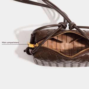 Brown quilted handbag with gold zipper on a white background