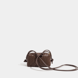 Brown woven handbag with a strap on a light gray background