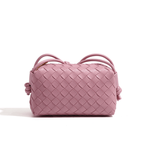 Pink woven handbag on a white background