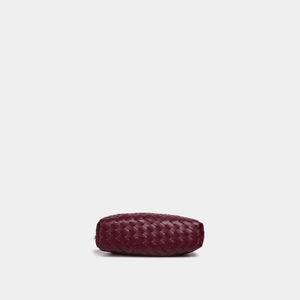 Maroon woven clutch bag on a light gray background