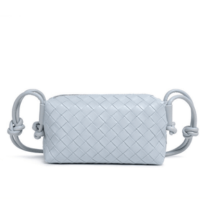 Light blue woven handbag with handle on a white background