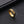 Gold ring with intricate design on a black textured surface