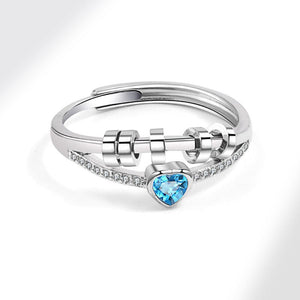 Silver ring with a heart-shaped blue gemstone on a white background