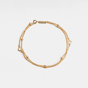 Gold bracelet on a light beige background