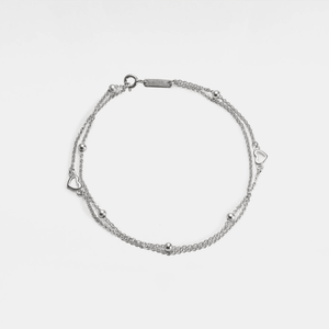 A gold-plated sterling silver bracelet with a double chain and heart-shaped beads.