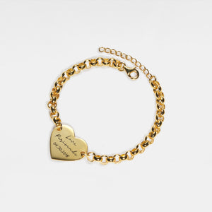 Gold bracelet with a heart-shaped tag on a white background