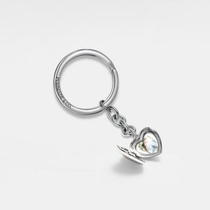 Keychain with a silver heart-shaped locket shown open, featuring a smooth polished exterior and a photo insert inside on a light gray background