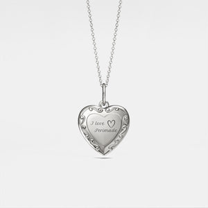 Silver heart-shaped locket with 'I love Permade' engraving on a light gray background