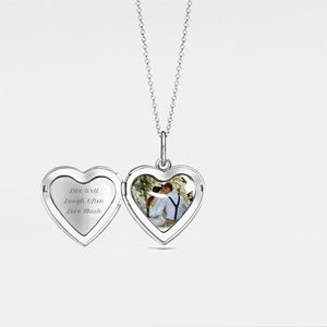 Silver heart-shaped locket shown open, featuring a smooth polished interior and a photo insert inside, displayed on a light gray background