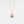 Gold heart-shaped necklace with a blue gemstone on a light gray background