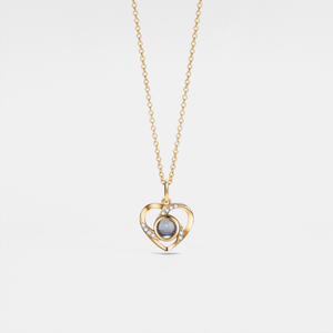 Gold heart-shaped necklace with a central pearl on a light gray background