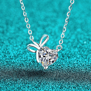 Silver necklace with a heart-shaped diamond pendant on a turquoise background