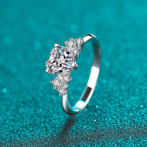 Silver ring with a diamond on a teal glittery background