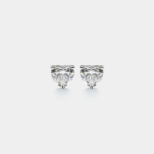 Heart-shaped diamond earrings on a light gray background