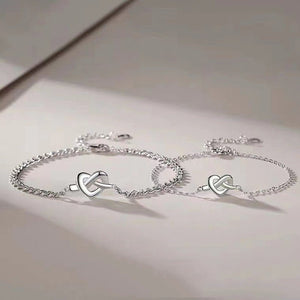 Silver bracelet with heart-shaped clasp on a light background