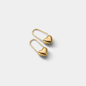 Gold heart-shaped earrings on a light gray background