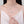 Heart-shaped necklace worn by a model in a white top